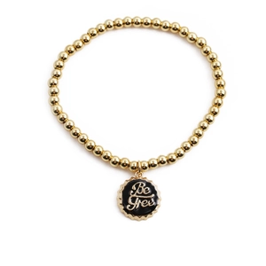 Goldenes Perlenarmband mit 'Be Free' Kronkorken-Anhänger auf weißem Hintergrund