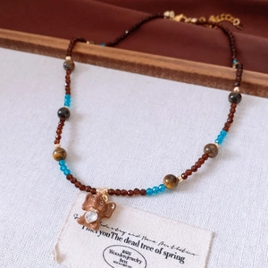 Détails du collier de perles avec pendentif éléphant marron et perles de verre bleues