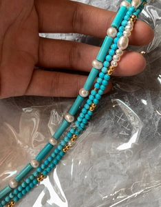 Macro shot of 18K gold plated necklace with turquoise beads and freshwater pearls