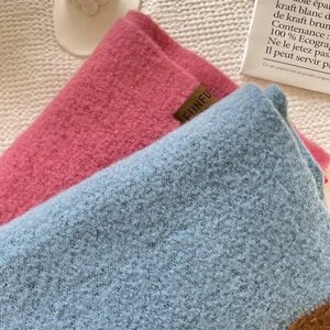 Detail shot of soft knit scarves in pink and light blue with premium plush texture