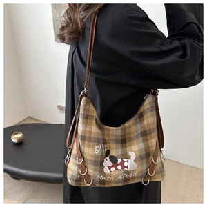 Close-up of wool plaid hobo bag in mustard yellow with leather strap and metal ring details