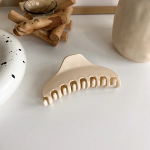 Detail view of large matte cream hair claw clip with wide curved teeth for long hair