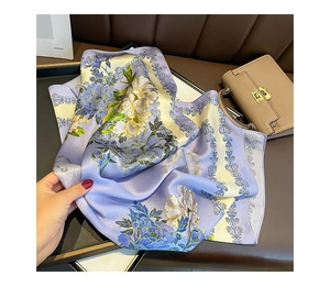 Detail of a purple floral silk scarf featuring elegant patterns and a soft texture