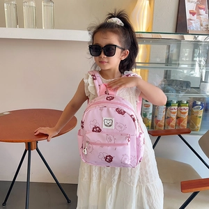 Zaino rosa per l'asilo con motivo a orsetto indossato da una bambina alla moda