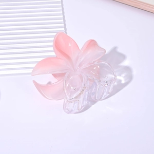 Close-up of a pink gradient frangipani flower hair claw clip with transparent details