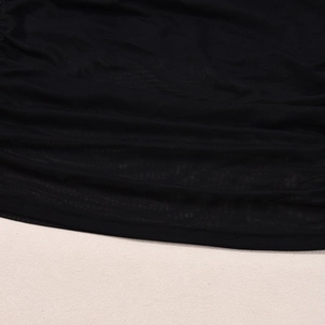 Détail en gros plan montrant la texture fine du tissu en maille noire et des fibres