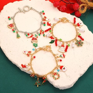 Christmas charm bracelets with Santa Claus and snowflake pendants on white stone stand
