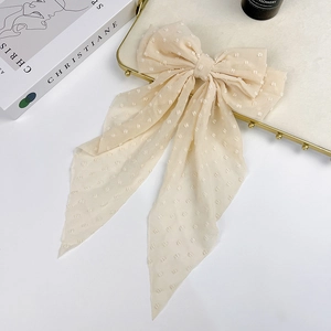 Detail view of the elegant beige polka dot mesh bow hair clip with long ribbons