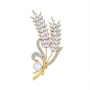 Detail of leaf-shaped brooch with sparkling rhinestones and a white pearl on white base