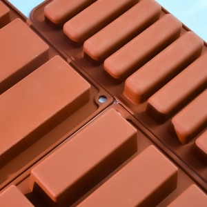 Detail van twee bruine siliconen mallen voor vingerkoekjes en chocoladerepen macro