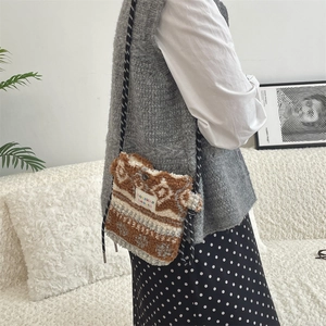Detail of plush rainbow polka dot bag showing soft texture and woven brand label