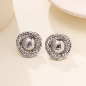 Macro detail of silver round stud earrings featuring vintage spiral texture and glossy finish