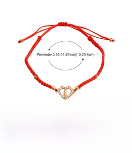 Detail of red woven bracelet with gold Virgin Mary heart charm and cross pendant