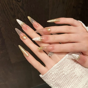 Long stiletto press-on nails with champagne gold glitter and marble texture detailing