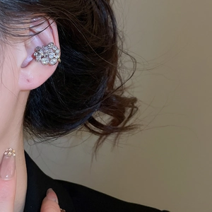 Détail d'un ear cuff floral argenté orné de cristaux de zircon sur le haut de l'oreille