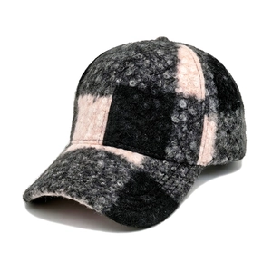 Close-up of thick plaid teddy fleece baseball cap with pink and grey checker pattern