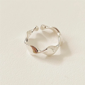 Macro detail of minimalist 925 silver wave ring with polished mirror finish texture
