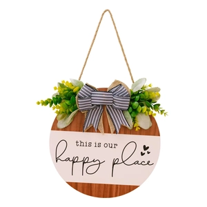 Detail of round wooden door sign with 'this is our happy place' text and a bow