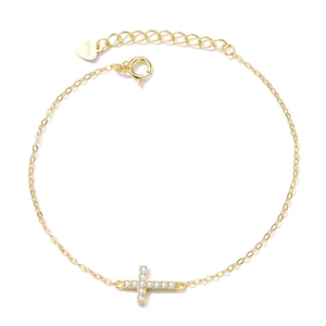 Detail of S925 sterling silver gold cross bracelet with shimmering clear cubic zirconia