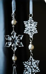 Macro shot of a transparent acrylic snowflake pendant with cream pearl and teardrop crystal