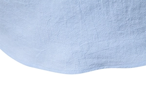 Detail of the stitching and natural texture on the hem of a light blue linen shirt