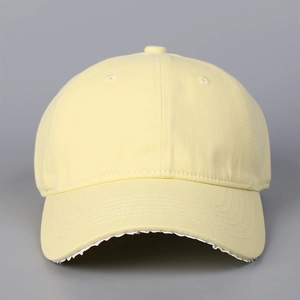 Détail de la casquette de baseball jaune clair avec bord effiloché et style vintage rétro