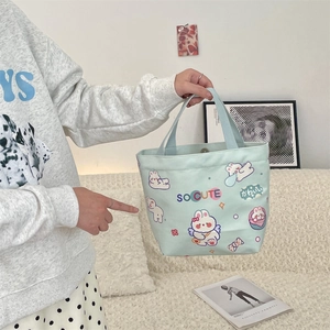 Detail of cute mint green canvas tote bag featuring rabbit print and snap button closure