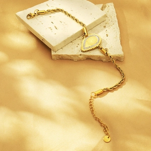 Detailed view of 18K gold plated coin bracelet with sparkling crystal teardrop charm