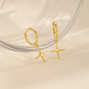 Close-up of golden S925 silver hoop earrings featuring sparkling star charms in a warm glow