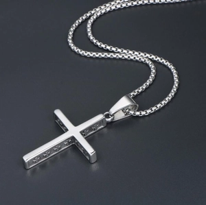 Detail of silver cross pendant with engraved patterns on a premium snake chain necklace