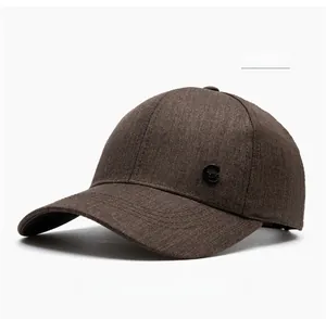 Detail of coffee brown textured knit fabric and circular metal G letter on baseball cap