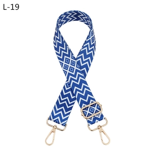 Dettaglio tracolla geometrica blu e bianca con fibbie in metallo dorato lucido