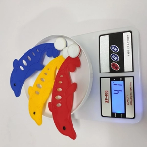Three colorful plastic dolphin pool toys weighing 41 grams on a digital scale for children