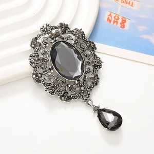 Vintage style black oval gemstone pendant with silver floral filigree and droplet charm