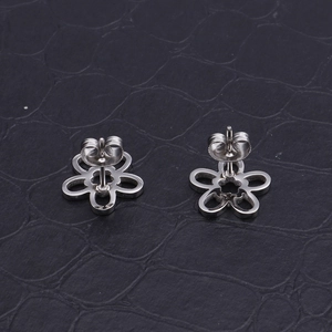 Makroaufnahme silberner hohler Sonnenblumen-Ohrstecker aus poliertem Edelstahl-Finish