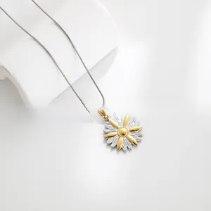 Detail view of a two-tone daisy pendant necklace with a silver and gold petal finish