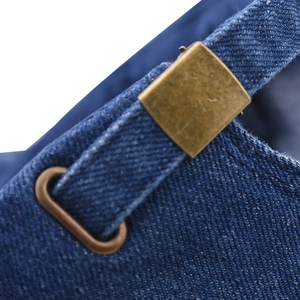 Detail of adjustable metal buckle on blue washed denim baseball cap with bronze hardware