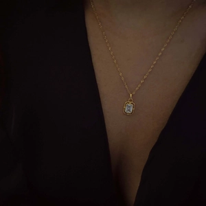 Macro detail of gold-plated stainless steel rope chain with a zircon rectangle pendant