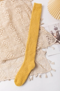 Detailed close-up of thick yellow coral fleece over-knee sock with soft plush texture