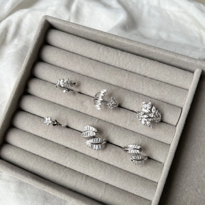 Detailed view of silver leaf rings with marquise zircon stones on velvet display tray