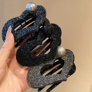 Detail of heart hair claws with crystals and large pearls in navy, black, and silver