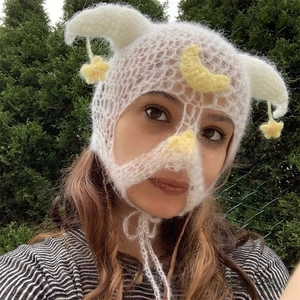 Detailed close-up of a white handmade crochet balaclava with devil horns and stars