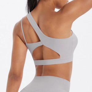 Detail of light gray sports bra featuring asymmetric strap and cutout back design