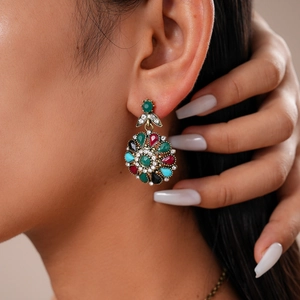 Detail of vintage flower-shaped earrings with colorful rhinestones on a model