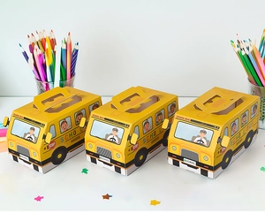 Yellow school bus gift boxes with stop sign print displayed next to colored pencils