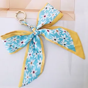Detail of camellia silk ribbon keychain with golden spring clasp and daisy pattern