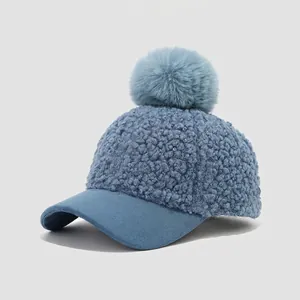 Detail of soft lamb wool baseball cap with faux fur pompom and suede brim for kids
