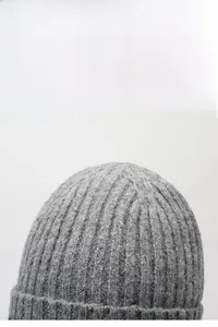 Close-up of the thick ribbed knit texture on a gray winter beanie for outdoor warmth