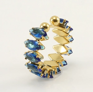 Precioso anillo abierto de acero inoxidable dorado con elegantes circones azules brillantes.