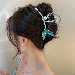 Detail of silver mermaid tail hair claw clip with blue enamel and pearl on model